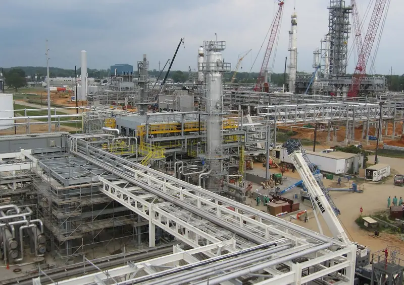 Oil and gas plant under construction with pipe racks and process columns